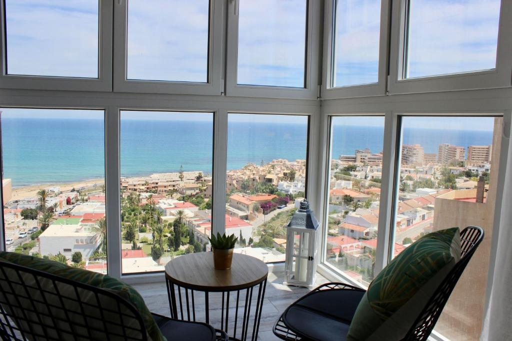 a room with a large window with chairs and a table at Apartamento con vistas al mar in Torrevieja