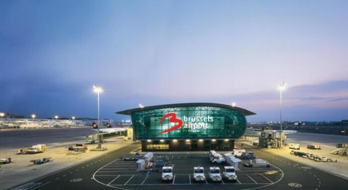 a building with cars parked in a parking lot at an airport at Airport Residence in Zaventem