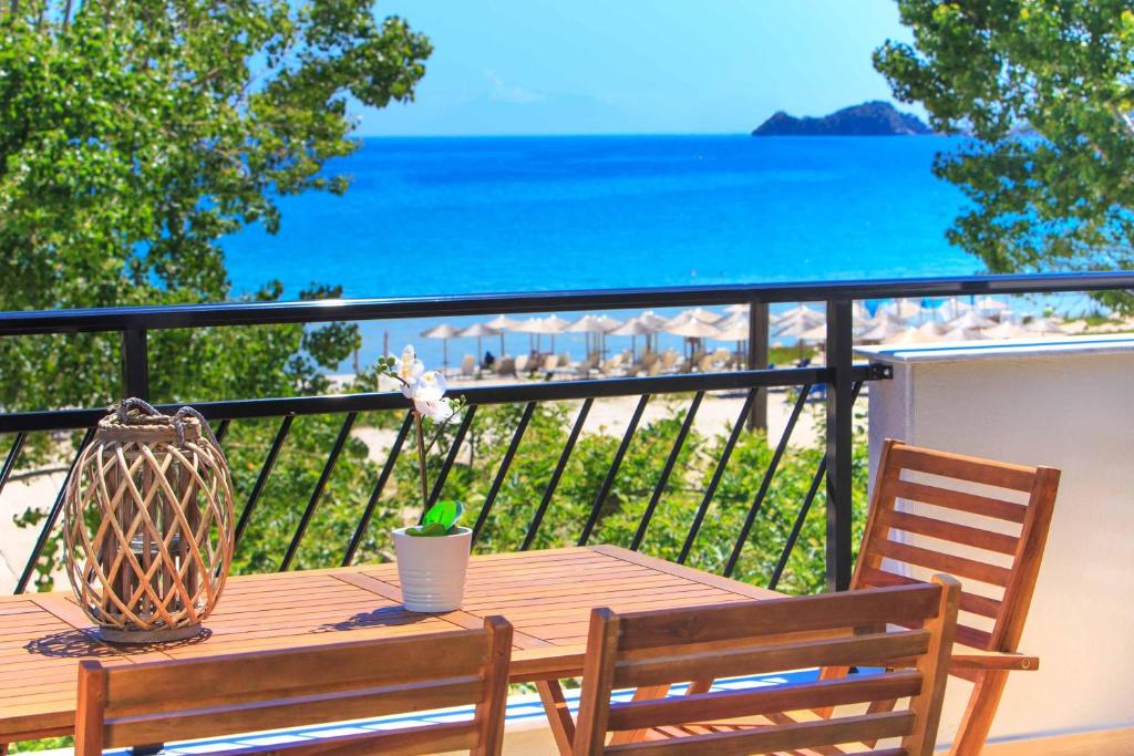 einen Holztisch mit einer Vase auf dem Balkon in der Unterkunft Studios Aigaio in Skala Potamias