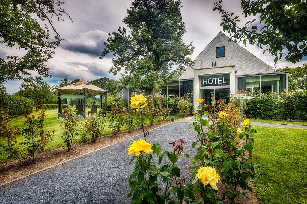 une maison avec beaucoup de fleurs dans l'allée dans l'établissement Cleythil Hotel, à Maldegem