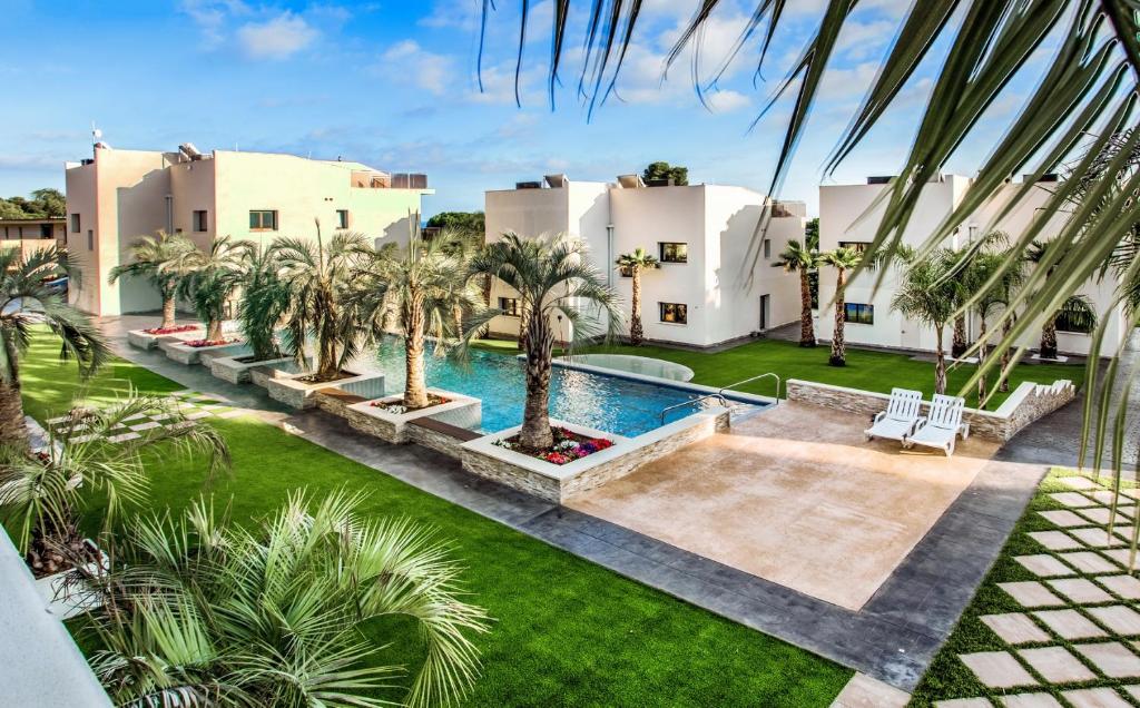 an aerial view of a house with a swimming pool and palm trees at Calma - HOLIDAY VILLAS in Platja  d'Aro