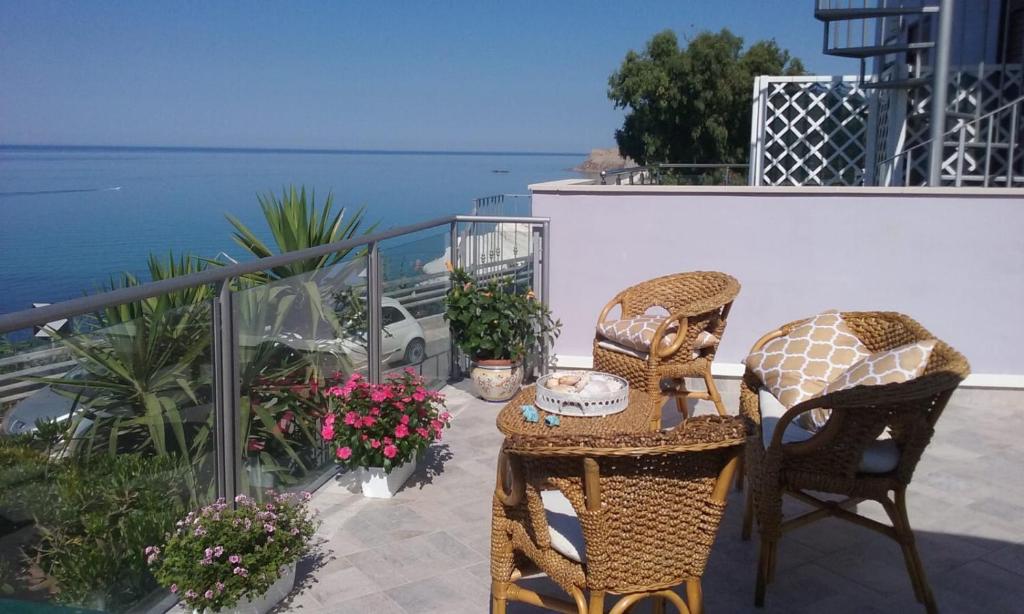 - une terrasse avec 2 chaises, une table et des fleurs dans l'établissement La Perla Scala dei Turchi, à Realmonte