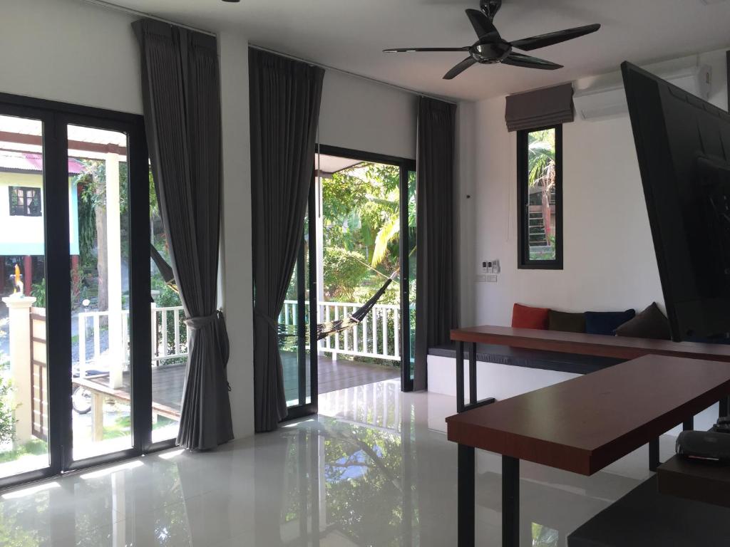 a living room with a ceiling fan and sliding glass doors at Reggae Village Haad Salad in Salad Beach