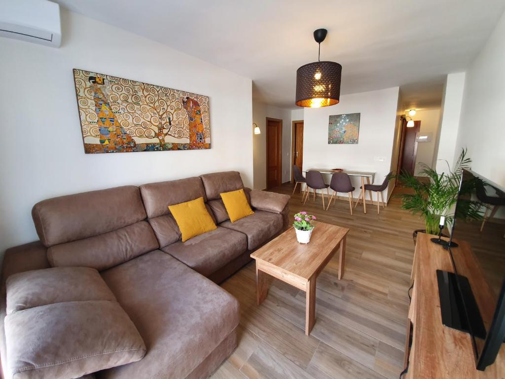 - un salon avec un canapé brun et une table dans l'établissement Gálvez Flat, at principal railway station in Málaga, à Malaga