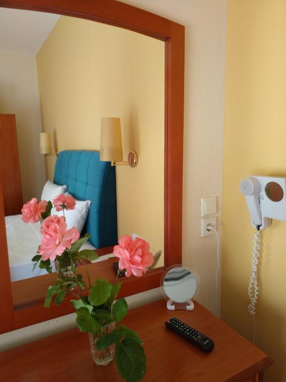 a room with a mirror and a table with flowers at Amalia in Paleo Tsifliki
