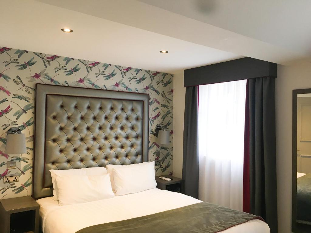 a bedroom with a large bed and a window at The Eaton Townhouse in London