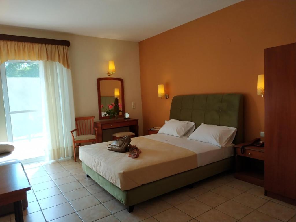 a hotel room with a bed and a mirror at Amalia in Paleo Tsifliki