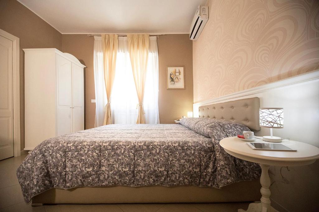 1 dormitorio con cama, mesa y ventana en B&B Brindesi, en Brindisi