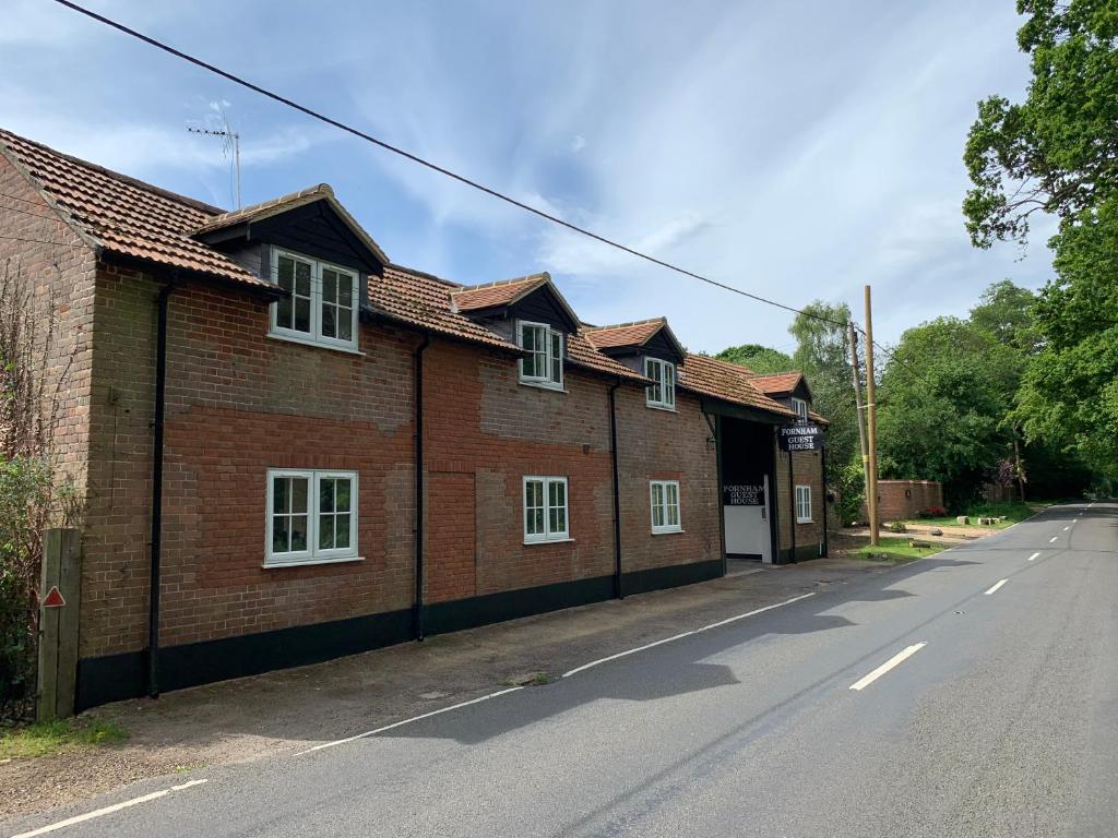 a row of brick houses on the side of a street at Fornham Guest House in Chertsey