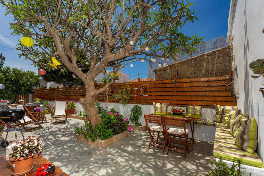 a patio with a tree and a table and chairs at Casa Maritina Traditional Family House in Gennadi