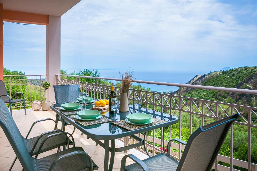 einen Tisch und Stühle auf einem Balkon mit Meerblick in der Unterkunft Villa Alessandra in Markópoulon