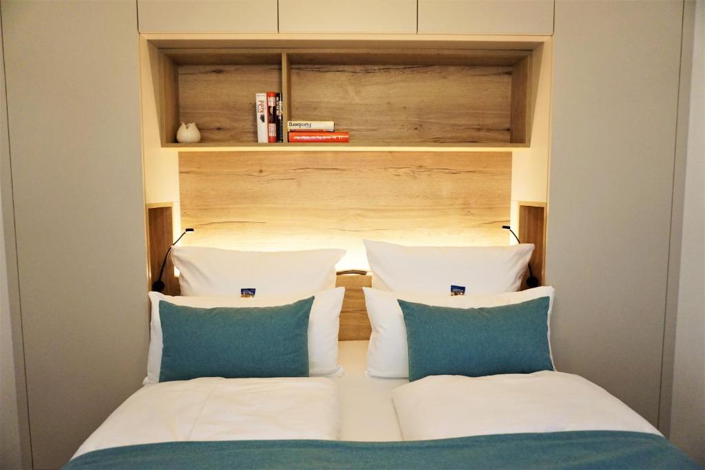 ein Bett mit zwei Kissen in einem kleinen Zimmer in der Unterkunft dieSonne in Weimar