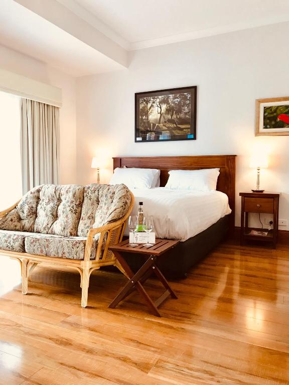 a bedroom with a bed and a couch and a table at Birdwood Motel in Birdwood