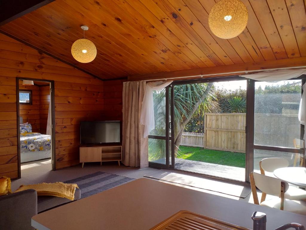uma sala de estar com televisão e uma grande janela em Cosy in central Rotorua em Rotorua