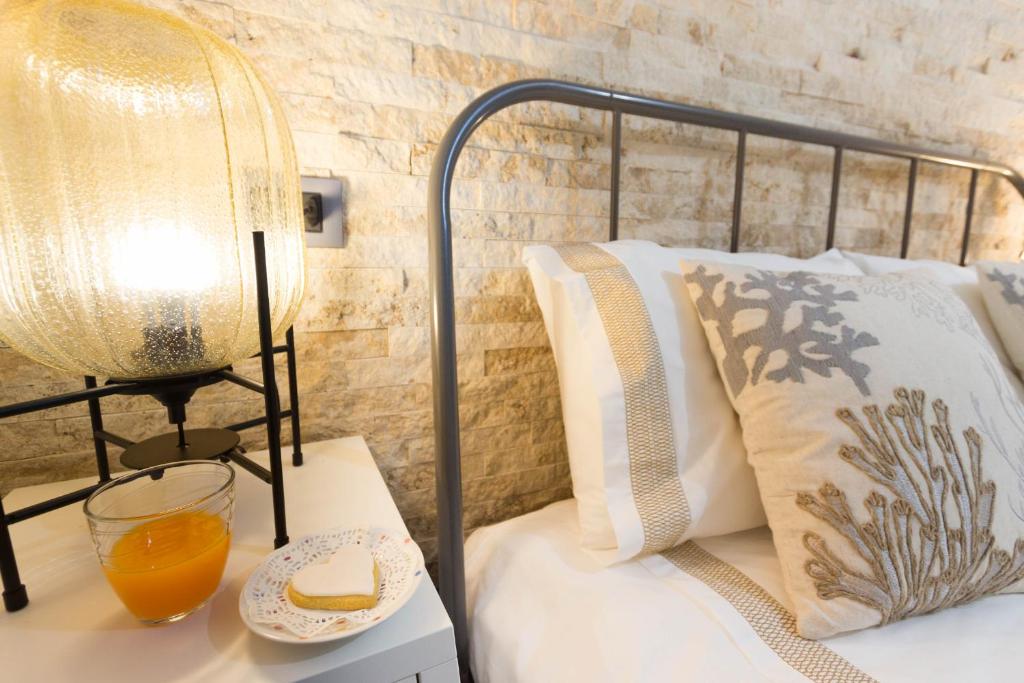 sypialnia z łóżkiem z lampką i talerzem sera w obiekcie Via San Giacomo 10 w Cagliari