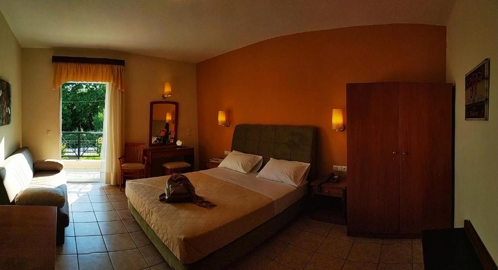 a bedroom with a large bed and a window at Amalia in Paleo Tsifliki