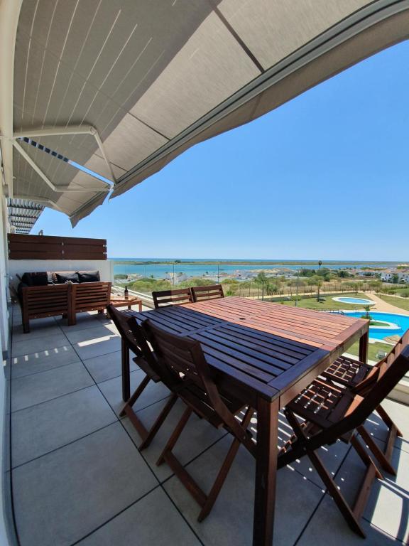 a table and chairs on a patio with a view of the ocean at ARCA DE BUEY LA RESERVA in El Rompido