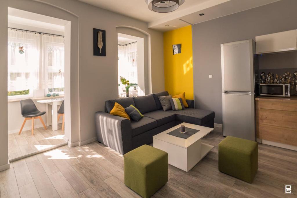 a living room with a couch and a kitchen at Apartamenty Słoneczne in Duszniki Zdrój