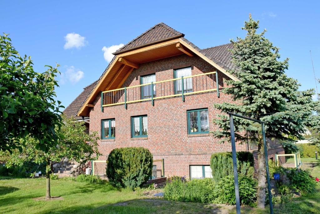 ein großes rotes Backsteinhaus mit Balkon in der Unterkunft Ferienwohnung Zudar auf Rügen in Zudar
