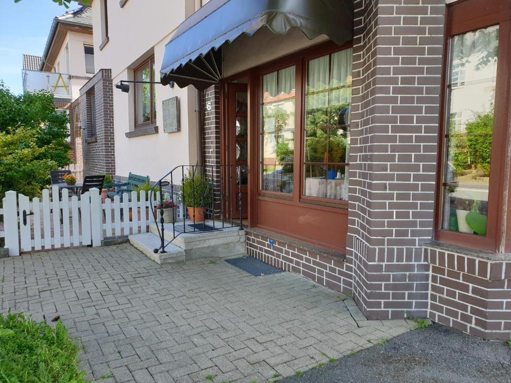 ein Haus mit einer roten Tür und einem weißen Zaun in der Unterkunft Gästehaus zum Georgenberg in Goslar