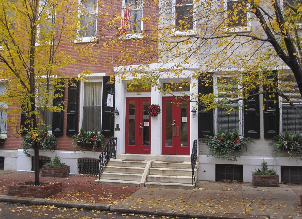 a red brick building with a red door leading to a garden at La Reserve Bed and Breakfast in Philadelphia