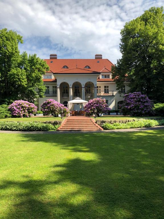 una casa grande con techo rojo y césped en Rezydencja Willa Park & Restauracja, en Legnica