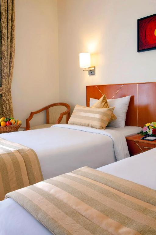 Postel nebo postele na pokoji v ubytování Landmark Hotel