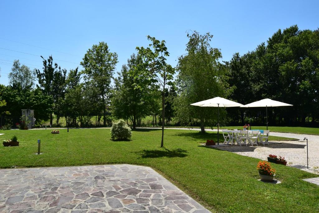 a park with tables and umbrellas in the grass at Casa Vacanza e per lavoro Tessyhouse in Spinea