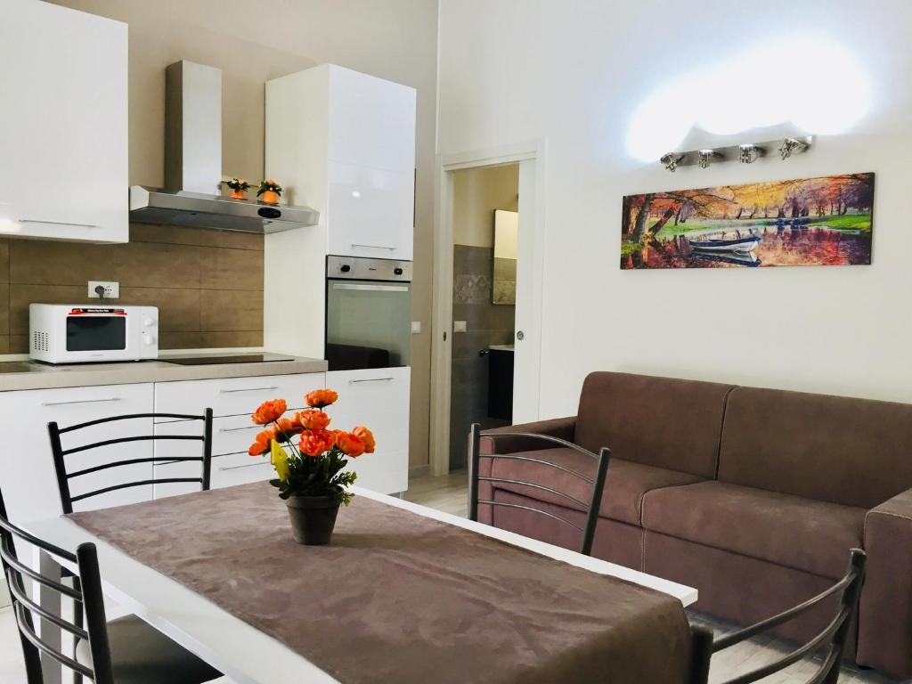 a kitchen and living room with a table and a couch at CASA ALBA in Lucca