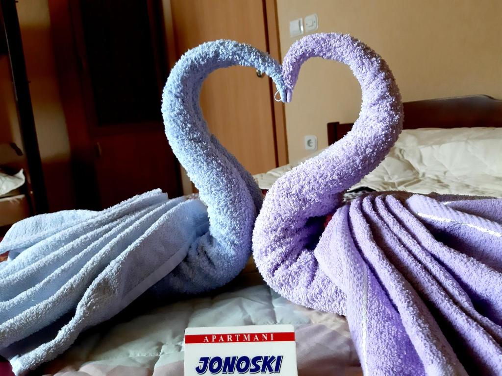 two towels shaped like swans sitting on a bed at Apartment Jonoski in Ohrid