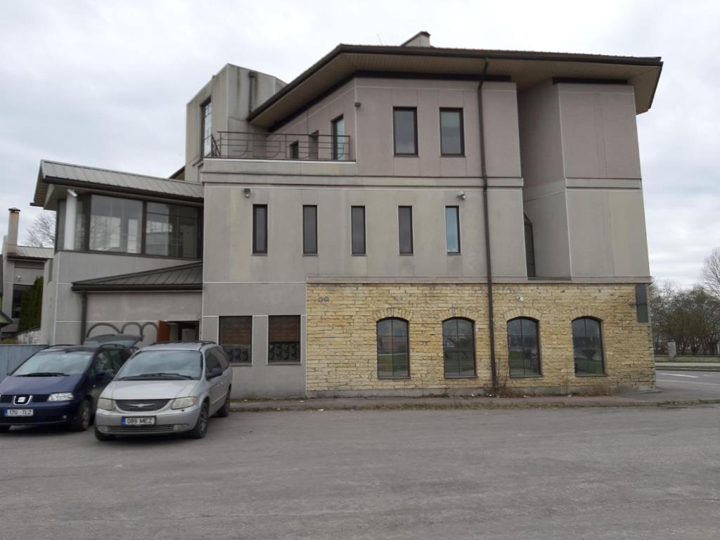 een gebouw met twee auto's geparkeerd op een parkeerplaats bij Majaka Hostel in Tallinn