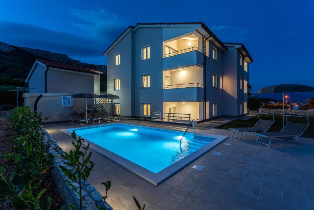 a villa with a swimming pool at night at Apartments Mateo 2 in Baška