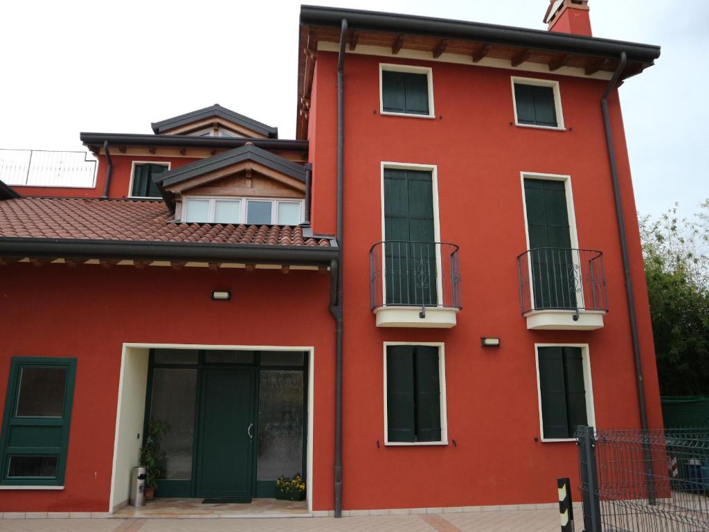 ein rotes Gebäude mit zwei Balkonen darauf in der Unterkunft B&B Primula House in Carmignano di Brenta