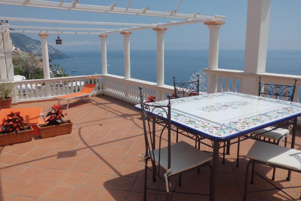 a table and chairs on a balcony with a view of the ocean at Little Flower in Positano