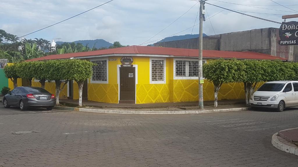 un bâtiment jaune avec un toit rouge dans une rue dans l'établissement Hostal Doña Mercedes, à Juayúa