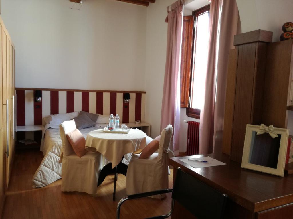 a room with a table and a bed and a table and chairs at La casa di Simona in Pistoia