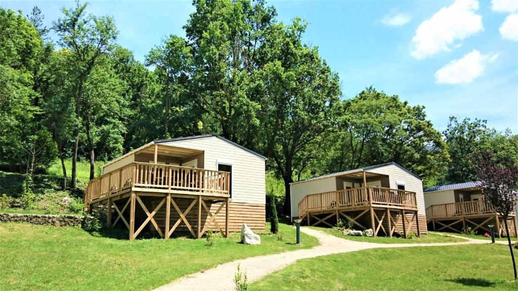 un grupo de cabañas con árboles en el fondo en Camping Les Framboiseilles, en Castellane