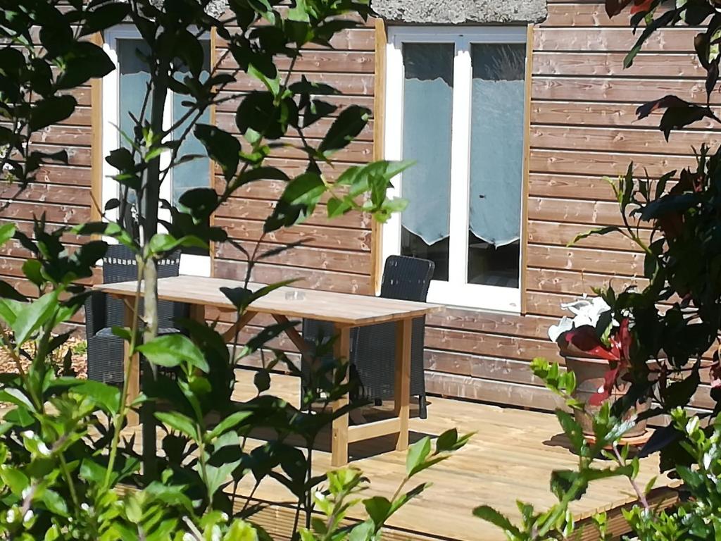 una mesa y sillas en una terraza de madera en Ti-Gwennel en Briec