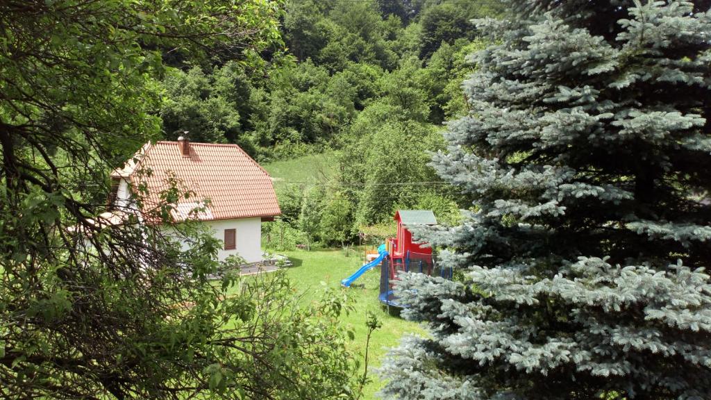 een huis met een blauwe glijbaan naast een boom bij Cottage Forest Stream in Visoko
