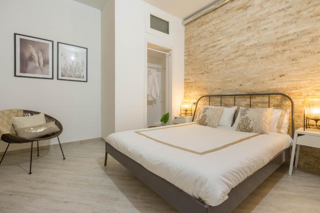 Un dormitorio con una cama y una pared de ladrillo. en Via San Giacomo 10, en Cagliari