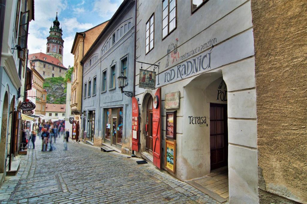 a cobblestone street in a city with people walking down it at Pension Pod Radnicí in Český Krumlov
