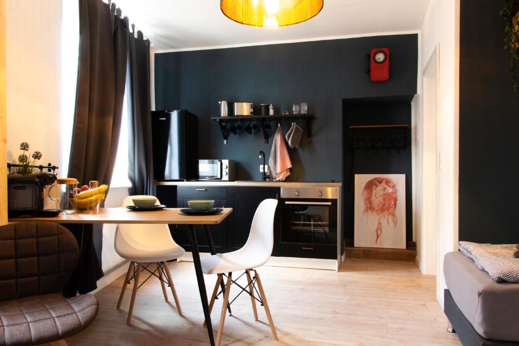 a kitchen with a table and chairs in a room at Rooms4ring UG Nürburgring Industrial Design House in Adenau