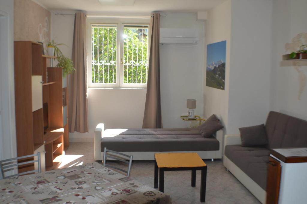 salon z kanapą i oknem w obiekcie Appartamento Mara w mieście Domodossola