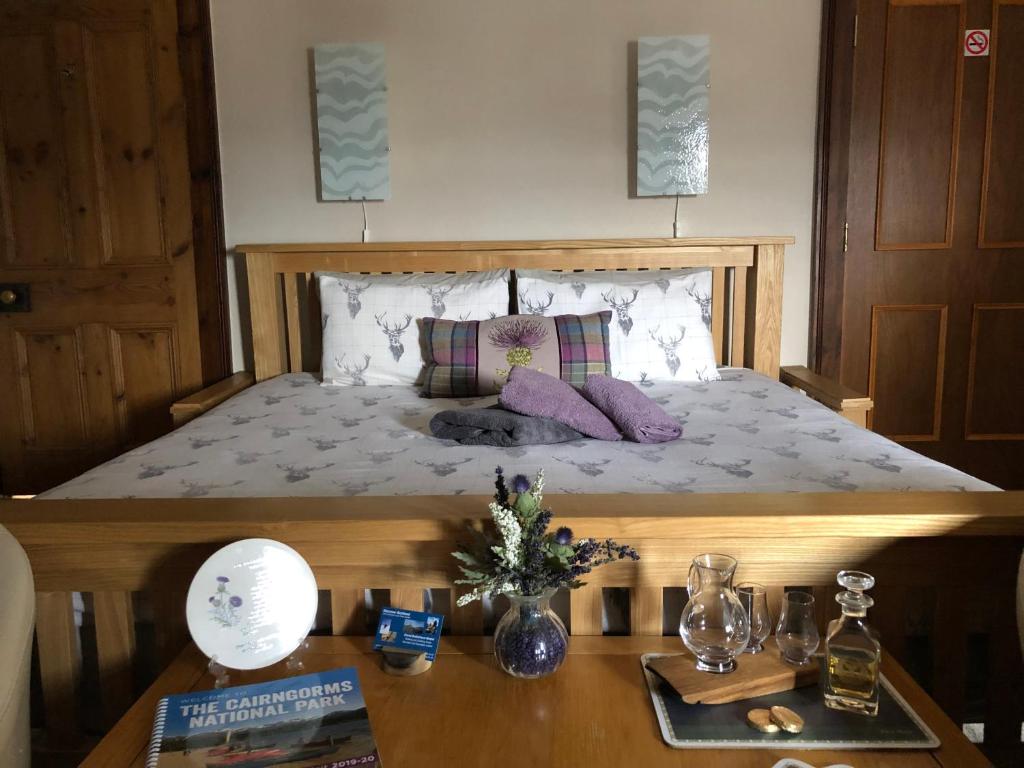 a bedroom with a bed and a wooden table with a table at Haus Alba in Grantown on Spey