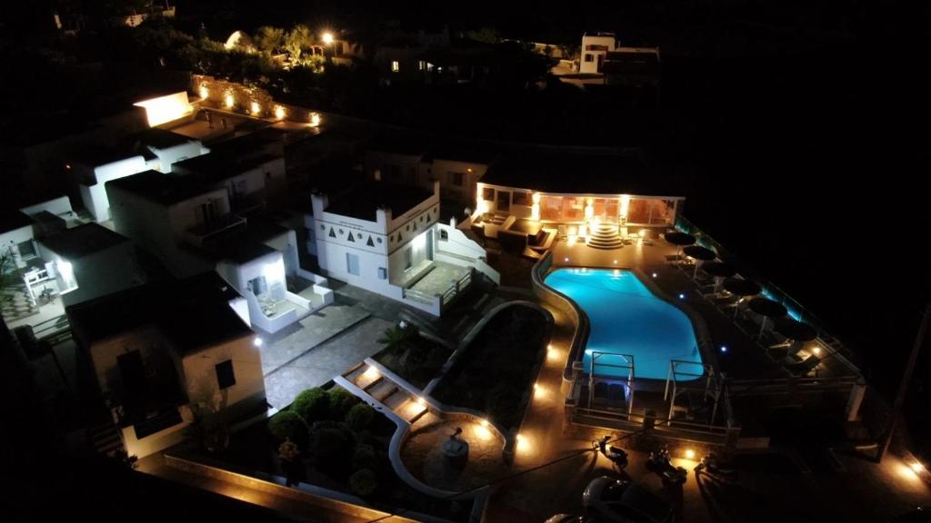 uma vista aérea de um edifício com uma piscina à noite em Casa Bianca em Ornos