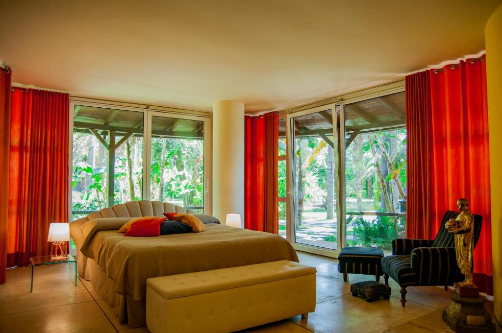 a bedroom with a bed with red drapes at B&B La Villa in Giardini Naxos