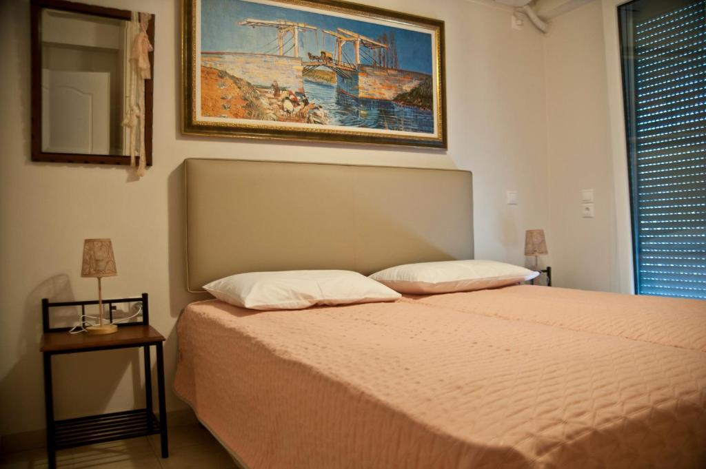 sypialnia z łóżkiem i zdjęciem na ścianie w obiekcie Chalkida Apartments w Chalkidzie
