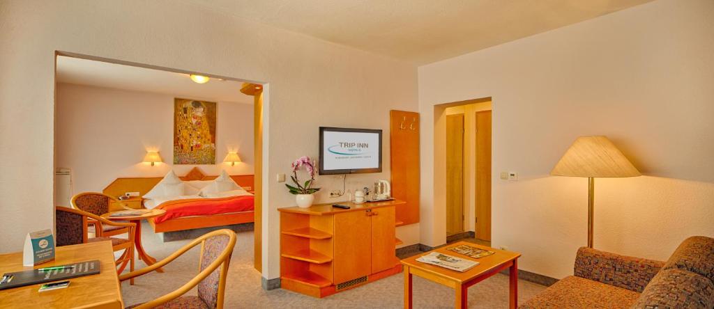 a hotel room with a bed and a living room at Trip Inn Hotel Zum Riesen Hanau in Hanau am Main