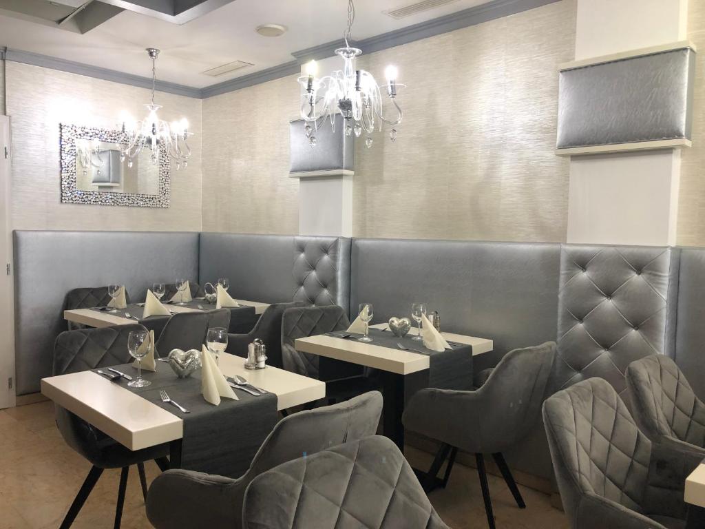 restauracja ze stołami i krzesłami oraz żyrandolem w obiekcie Teátrum Boutique Hotel w Győr
