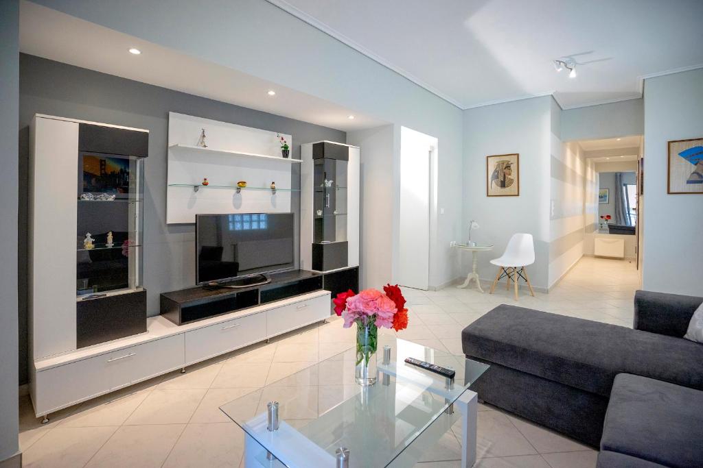 a living room with a vase of flowers on a glass table at Leo's home in Athens